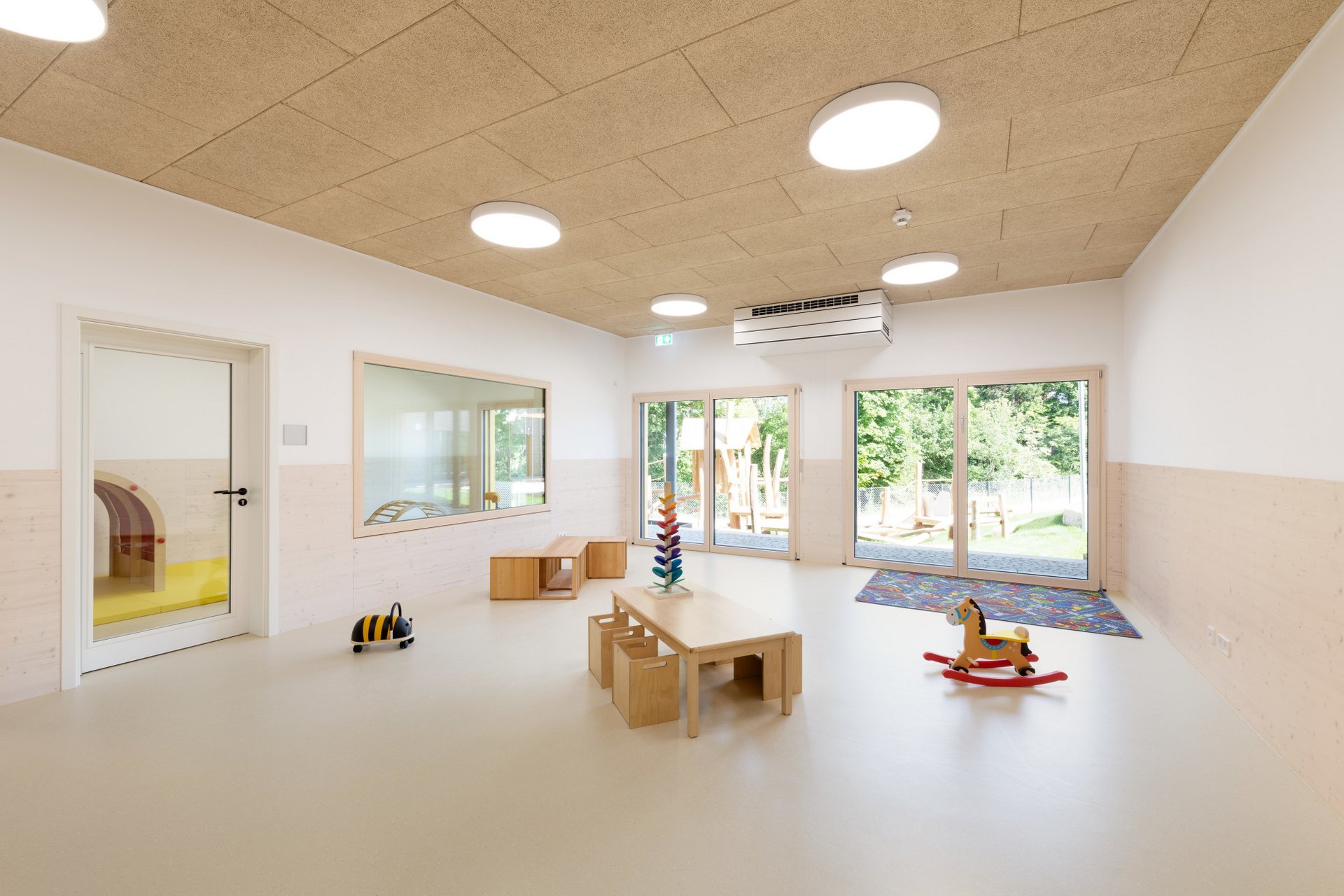 Innenansicht eines Spielzimmers mit Möbeln aus hellem Holz
