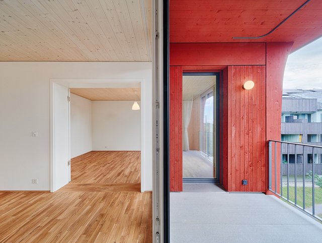 Hirtenweg, Riehen Hirtenweg, Riehen - Frontales Bild geteilt in Innenraum in wiess mit mittig Balkontüre rechts Balkon mit roter Fassade