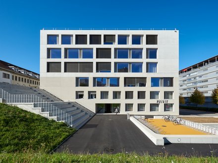Haute école de sante et de travail social, Fribourg - Pfosten-Riegel-Fassade, grosser Treppe und Veloabstellplatz