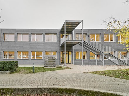 Schulprovisorium, Kilchberg  - Aussenansicht des Schulprovisoriums mit ausgelagertem überdachtem Treppenhaus und Pausenhof