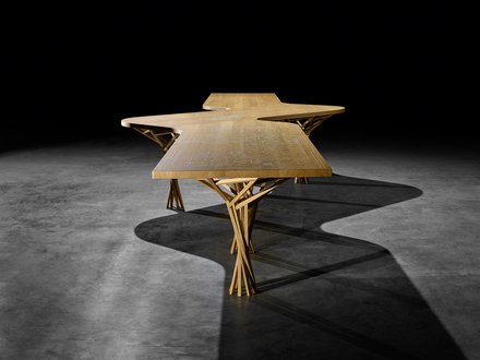 Langer Holztisch mit eingravierter Firmengeschichte und filigranen Holzbeinen parametrisch designet