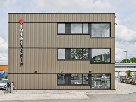 HEK interstein, Münchwilen - Aussenansicht des Gebäudes von vorne mit Metallfassade und grossen Fenstern HEK interstein, Münchwilen - Aussenansicht des Gebäudes von vorne mit Metallfassade und grossen Fenstern