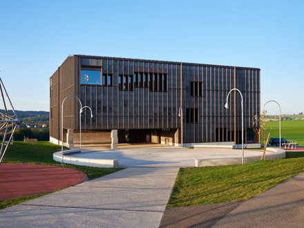 Grangecole, Villorsonnens - Schulgebäude mit auffallender Fassade aus Kupfer und Pfosten-Riegelelemente 