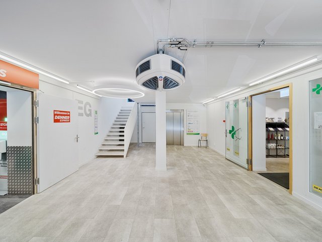 Einkaufszentrum Liebrüti, Kaiseraugst - Innenansicht des Gangs mit Treppenhaus, rechts Lebensmittelladen und links Zahnartzpraxis