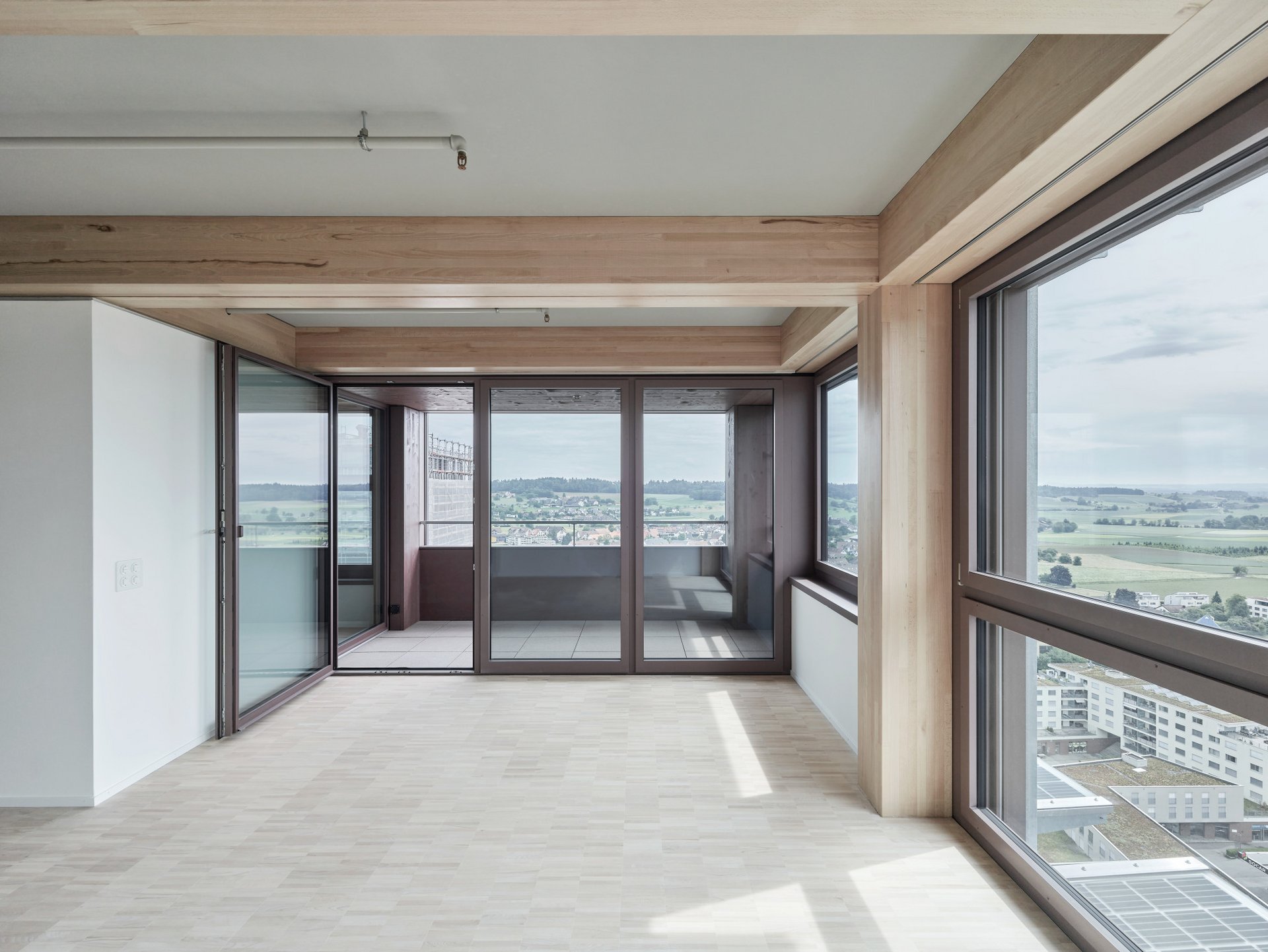 Innenansicht einer Wohnung mit Ausbilck durch deckenhohe Fenster 