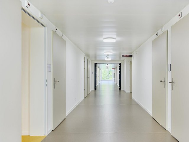 Geriatrische Klinik, St.Gallen - Langer, heller Korridor mit Digitaler Zeitangabe