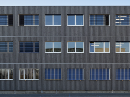 Le Martinet 2, Rolle - Aussenansicht frontal mit dunkles Fassade und Pausenhof 