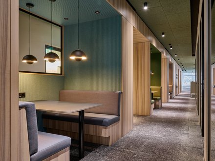 Kalaidos, Zürich - Besprechungsbereich in Mittelzone in Grossraumbüro mit Polstern und Tisch