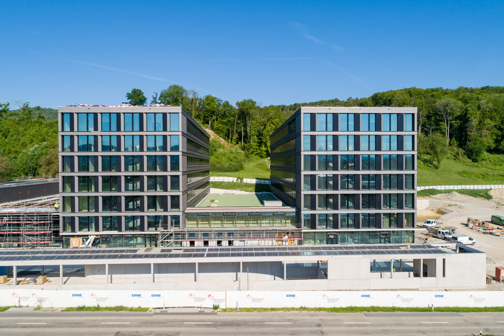 Gebäudekomplex mit grossen Fenstern und Photovoltaik Panels auf dem Dach