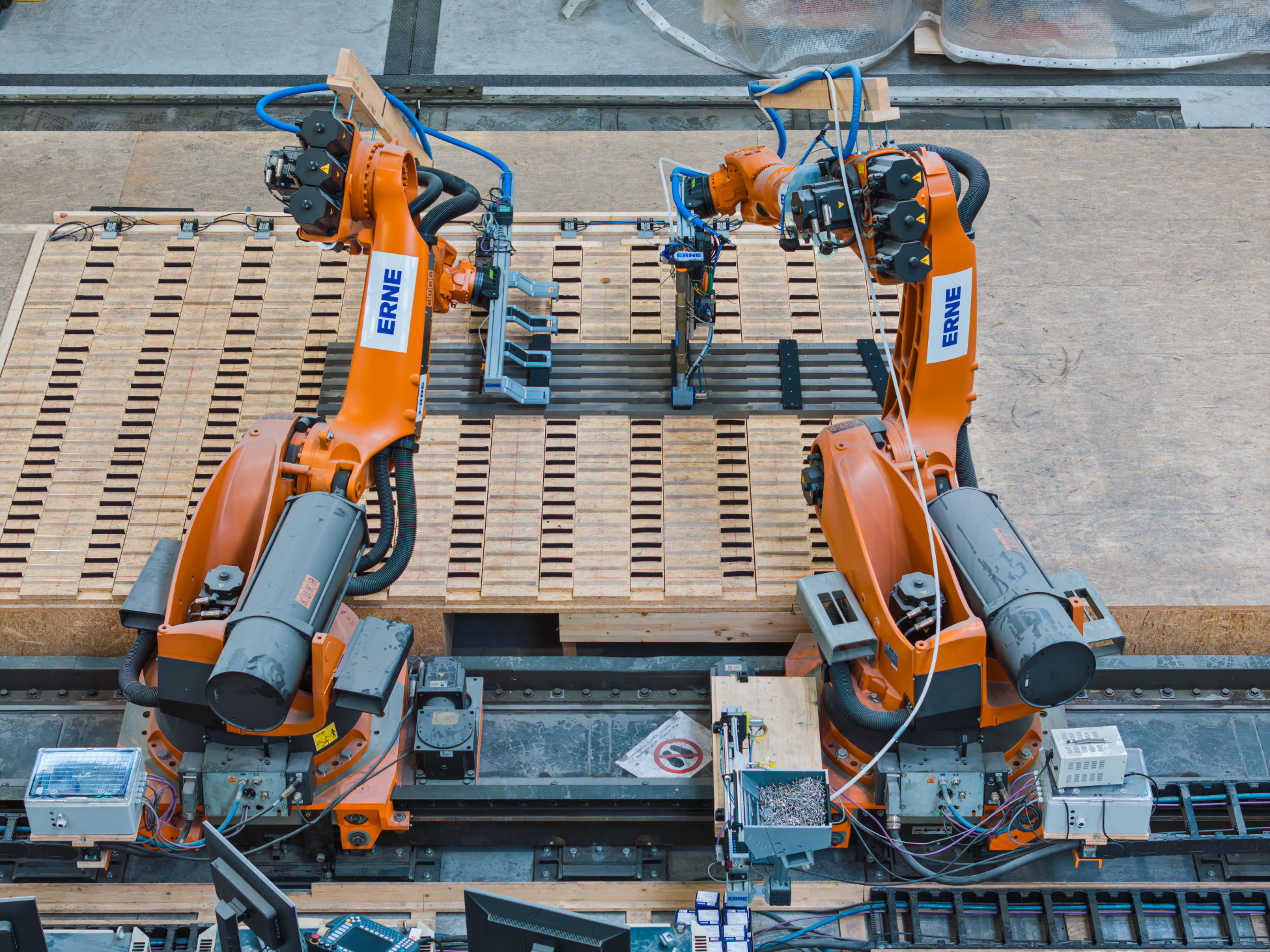 ERNE Fassadenroboter in orange fertigt ein Fassadenelement auf einer Schablone